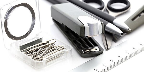 Bürobedarf: verschiedene Büromaterialien wie Tacker, Schere, Lineal und mehr auf einem Tisch. 